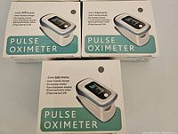 Three boxed fingertip pulse oximeters with product images and features visible on the packaging.
