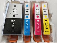 Four compatible replacement ink cartridges labeled 902XL in black, cyan, magenta, and yellow colors.