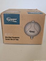 Front side of cardboard packaging box showing Hygger brand logo, HG-811 model, and product name as Ultra-Silent Piezoelectric Ceramic Mini Air Pump.