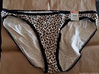 Jenni bikini bottom in cheetah print with black lace trim shown flat with visible brand tag and size 3XL label.