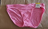 Front view of hot pink bikini bottom with Jenni tag attached.