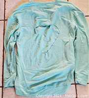 Back view of teal long sleeve shirt showing heart-shaped cutout detail