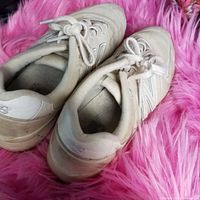 Side and top angle view of the white and beige New Balance sneakers showing laces, suede material and overall condition of shoes.