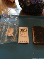 Photo showing the vintage book next to a lot tag and plastic wrapping with handwritten labels describing the book.