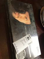 Photo of the sealed black box featuring a close-up photo of Garth Brooks wearing a black hat. Price tag visible.