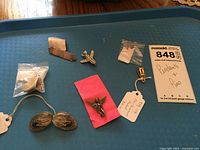 Lot of various costume pendants and pins including a sterling silver bar pin displayed on a tray.