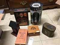 Photo shows a collection of multiple decorative boxes and containers arranged on the floor.