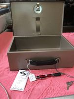 Open metal lock box showing inside and locking mechanism on lid