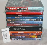 Set of 13 rock DVDs stacked showing titles such as U2 Elevation 2001, Foo Fighters, Godsmack, Elvis Presley and more.
