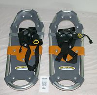 Pair of aluminum Powder Ridge snowshoes shown from top view on white background, featuring orange cross straps and black adjustable bindings.