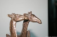 Close-up of two brass giraffe heads showing detailed textures and shapes