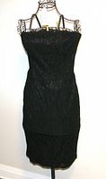 Full front view of black strapless lace dress on a hanger showing the fitted silhouette and knee-length hemline.