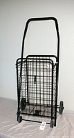 Front view of the black metal wire basket cart with handle and two rear wheels