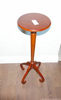Full view of wooden Bombay plant table showing tall slender leg and tripod base.