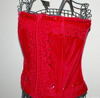 Front and side view of red velvet bustier showing lace and sequin embellishments on mannequin.