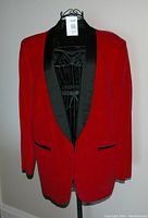 Full front view of vintage red velvet tuxedo jacket with black satin shawl collar and two welt pockets.