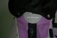 Close-up of Dunlop logo on purple and white golf bag with black accents.