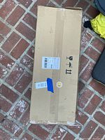 Box of the Amazon Basics recycled wood rectangular garden planter. The box is sealed with labels and shipping information visible.