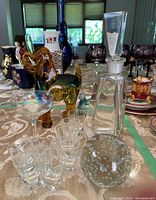 Overall table view including decanter, dog figurine, glasses, and other items.