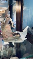 Full view of Lladro porcelain figurine showing a young girl and aggressive goose on floral base.