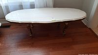 Full front view of oval marble coffee table showing top and base