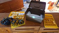 Plastic storage bin and yellow plastic organizers contain multiple bracelets and earrings.
