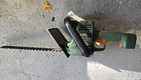 Full view of electric hedge trimmer showing blade and handle including safety guard.