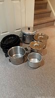 Overview of all pots and pans showing roasting pans, boiling pots, pickling pot, and smaller pots with and without lids.