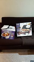 Hamilton Beach slow cooker in original box, 4-quart capacity, with packaging and manual on top of the box placed on a brown couch.