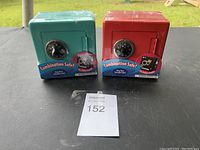 Two new combination safes, turquoise and red, in shrink wrap with packaging.