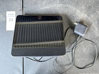 Front view of the Facebook Portal smart display showing screen, camera, speaker, and power adapter cable.