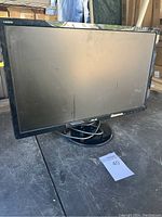 Front view of ASUS VE245H monitor on a table showing screen and circular base stand.