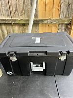 Full view of the black Sterilite storage trunk with white handle and metal latches on the front, showing overall condition.