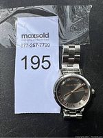 Front view of Michael Kors wristwatch with visible black and silver dial and Roman numerals.