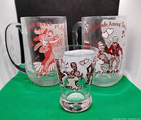 Three vintage sing along glasses with printed lyrics and music notes, two large mugs with handles and one smaller glass without handle.