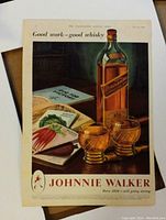 Photo of original vintage Johnnie Walker whisky advertisement from a UK magazine, featuring the bottle, two glasses, and related imagery.