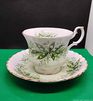 Front view of the tea cup and saucer set showing floral pattern and gold rim.