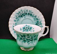 Tea cup and saucer set displayed separately, showing detailed floral pattern and gold accents