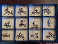 Full set of 12 hand painted vintage cowboy pins displayed in blue bordered cards marked 'HAND PAINTED'. Some cards have damaged plastic covers.