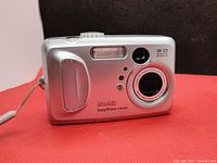 Front view of the Kodak EasyShare CX6230 silver digital camera showing lens, flash, and grip