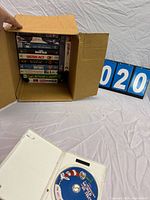 Box holding stack of VHS tapes with front view, Dr. Seuss DVD case in foreground
