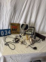 All items arranged on table: mirror, art, plaque, deodorants, styling tools, power bar, wood stand