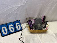 Basket containing curling iron, hairbrush, wig in bag, press-on nails