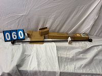 Full view of brown metal curtain rod, finials attached, cardboard packaging