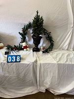 Overall lot showing garland, urn with tree, plush bear, mug package