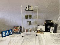 Overall lot showing cart with shelves, mugs, appliance and boxed items