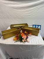 Three gold-tone metal flower boxes, faux floral bouquet displayed on table