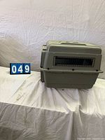 Side view of gray plastic kennel showing ventilation grille