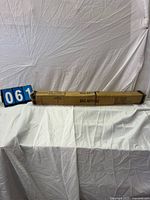 Long closed cardboard box labeled SKU AD11-003 with umbrella pictogram