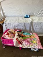 Pink toddler bed with Disney Princess bedding displayed